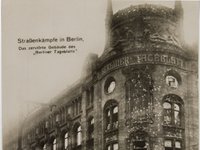 Straßenschlachten in Berlin. Im Hintergrund das ausgebrannte Gebäude des "Berliner Tageblatts"