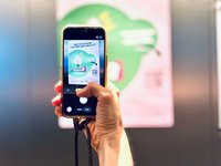 Augsburg Checkts Plakat wird mit dem Smartphone fotografiert