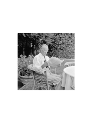 Konrad Adenauer, sitzend und Zeitung lesend