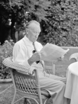 Konrad Adenauer, sitzend und Zeitung lesend