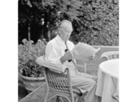 Konrad Adenauer, sitzend und Zeitung lesend