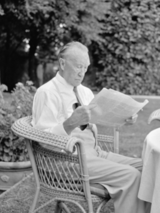 Konrad Adenauer, sitzend und Zeitung lesend