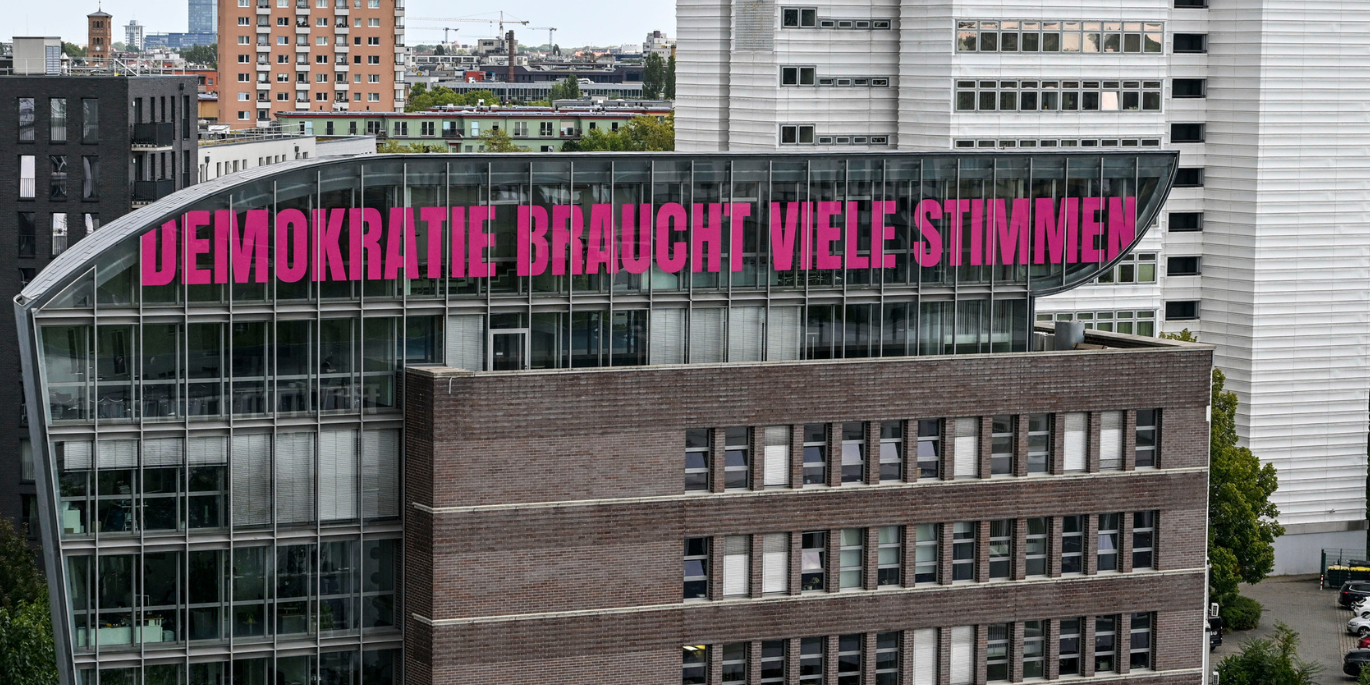 Haus der Presse beklebt mit Titel Demokratie braucht viele Stimmen